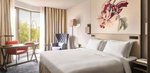 阿姆斯特丹阿姆斯特丹凯悦酒店的配有一张床、一张书桌和一扇窗户的酒店客房