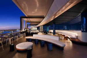 悉尼悉尼凯悦酒店的大楼顶部的餐厅,设有桌子和长凳