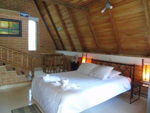 圣奥古斯丁ASGARD Spa的卧室配有白色床和木制天花板