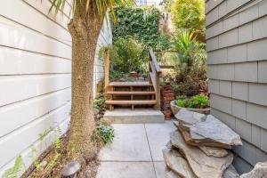旧金山Secret Garden Stay - Perfect SF Location的树旁的天井,设有木凳