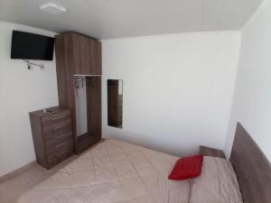 查哈里Alojamiento en Chajarí的一间卧室配有一张床、梳妆台和电视。
