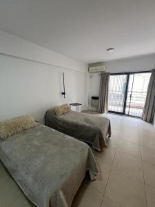 布宜诺斯艾利斯Departamento en San Telmo的一间卧室设有两张床和大窗户