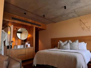 拜伦湾Hotel Marvell Byron Bay的一间卧室配有一张大床和镜子