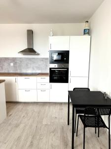 PrievozBanselova apartment的厨房配有白色橱柜和黑色桌子