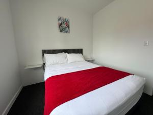 奥拉涅斯塔德Central Boutique Hotel的卧室配有一张带红色毯子的白色床