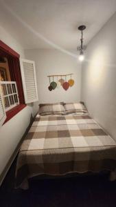 圣若昂-德雷CASA DOS SINOS的一间卧室配有一张带 ⁇ 子毯子的床