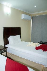 马翁Kamanga Safari Lodge的一间卧室设有两张带白色床单的床和窗户。