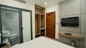 邦美蜀Thành Thuý Hotel的一间卧室配有一张床和一台电视,还设有一间浴室