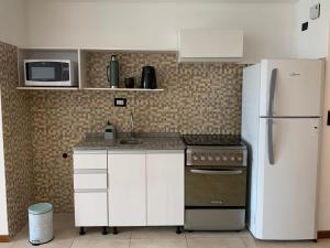 布宜诺斯艾利斯Monoambiente nuevo y luminoso en Flores的厨房配有白色橱柜和冰箱。