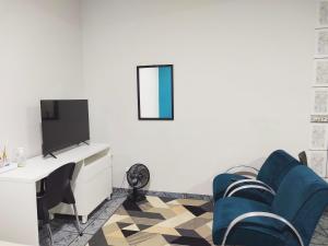 卡夸尔Apartamentos aconchegantes no centro da cidade的客厅配有电视和蓝色椅子