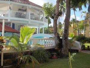 EslabónHotel V. Maria的带阳台和棕榈树的大型白色房屋
