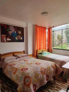 HuantaHOTEL HUANTA - MORENOS的一间卧室设有两张床和窗户。