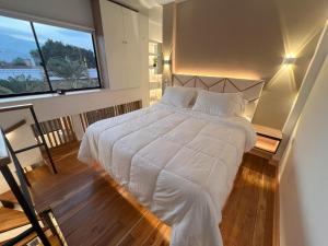 麦德林'SELECT' Medellin的卧室配有白色的床和大窗户