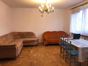 波兹南Noclegi Room Odlot Ławica 24h的客厅配有沙发和带笔记本电脑的桌子