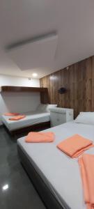 HYTON GRAND的一间卧室配有两张床,备有橙色毛巾