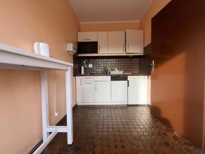 弗莱堡Simplex Apartments An Der Dreisam的一间小厨房,配有白色橱柜和瓷砖地板