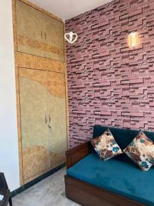 潘切库拉Authentic Indian Culture的一间设有蓝色沙发和砖墙的房间