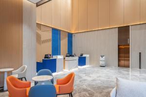 长沙长沙雨花智选假日酒店的大堂设有蓝色和橙色的椅子和桌子