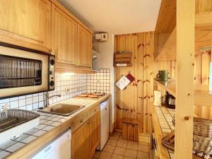 孔布卢Appartement Combloux, 3 pièces, 5 personnes - FR-1-560-120的厨房配有木制橱柜、水槽和微波炉