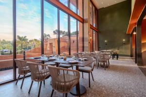 奥南海滩Hotel Adam Krabi的餐厅设有桌椅和大窗户。