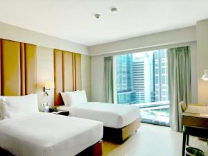 曼谷Ramada by Wyndham Bangkok Sukhumvit 11的酒店客房设有两张床和大窗户。