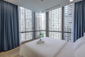 胡志明市Vinhomes Central Park Apartment- Landmark Luxury的卧室设有白色的床和大窗户
