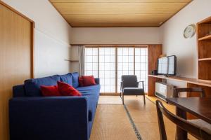 野沢Vaisala的客厅配有蓝色沙发和红色枕头