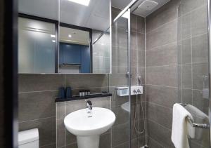 束草市Sokcho Chonpines Beach Hotel的一间带水槽和玻璃淋浴的浴室