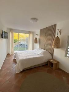 勒卡尔贝Villa Indigo的一间卧室设有一张床和一个大窗户