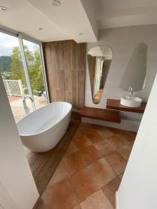 勒卡尔贝Villa Indigo的浴室配有大型白色浴缸和水槽