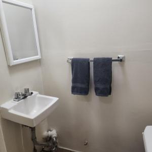 纽约New York City GuestHouse的浴室设有水槽、镜子和蓝色毛巾