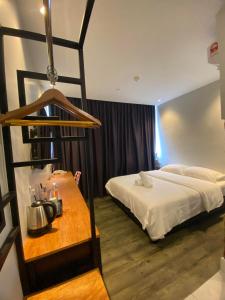 阿罗士打Super 8 Hotel Alor Setar的酒店客房配有一张床、一张桌子和茶壶