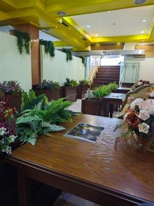 地拉那Hotel Artist的一间设有花卉大木桌的房间