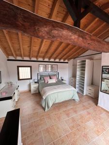 塞埃欣Casa Rural El Alcázar - Cehegín的一间卧室设有一张床和木制天花板