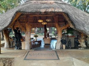 Karongwe Game ReserveKarongwe River Lodge的一个带茅草屋顶的大型木制凉亭