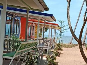 Ban Hin Sam KonHomeState Bang Maprao的海滩上多彩的房子,配有椅子