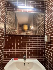 马杜赖THE ALP HOTEL Bypass Road的浴室设有白色水槽和镜子