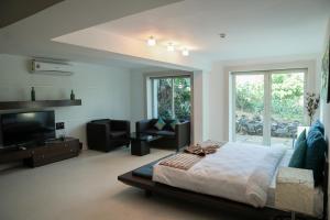 比纳里姆Beach House Resort Goa的一间卧室配有一张床和一台平面电视