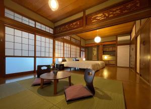宫崎貸切宿KUMANO的卧室配有一张床和一张桌子
