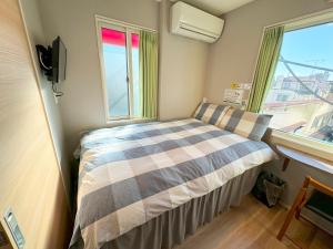 东京SHINJUKU WARM HOUSE的一间小卧室,配有床和窗户