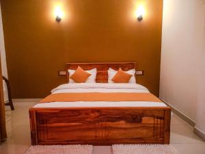 埃拉Ella, Nine Glow Resort的一间卧室配有一张带枕头的大型木制床。