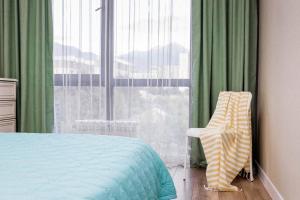 阿拉木图Heaven 2-Room Apartment`s的卧室配有床、椅子和窗户。