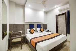 新德里Hotel S B INN - Near New Delhi Railway Station Paharganj的卧室配有1张床、1张桌子和1把椅子