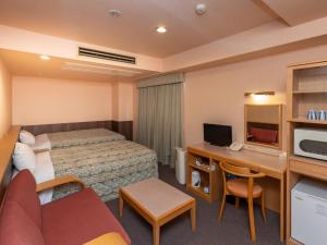 弘前市Tabist Hirosaki Touei Hotel的配有一张床和一张书桌的酒店客房