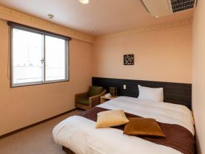 弘前市Tabist Hirosaki Touei Hotel的一间卧室设有一张大床和一个窗户。