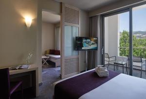 阿默达拉-伊拉克利翁Atlantica Akti Zeus Hotel的配有一张床和一台平面电视的酒店客房