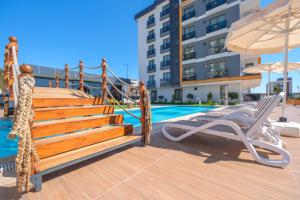 安塔利亚Elysium Deluxe Suites Antalya的游泳池设有躺椅和遮阳伞。
