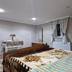 茨卡尔图博Colchis Guest House的一间卧室配有一张大床和一张桌子