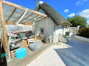 圣让-德蒙Apb-Spa cottages et Apb BnB avec piscine的茅草屋顶房屋 - 带天井