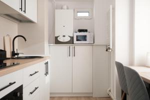 雅西Konstanzer Nicolina12的厨房配有白色橱柜和微波炉